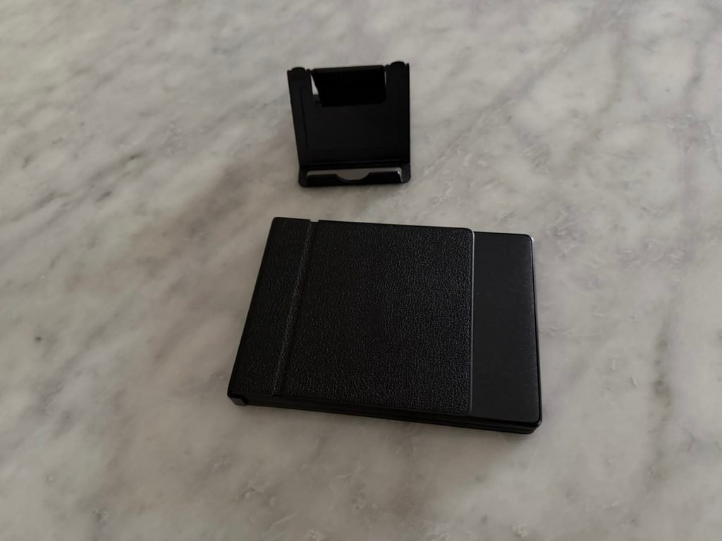 Minimalist portable tech accessories featuring a folded keyboard and a mobile phone stand.